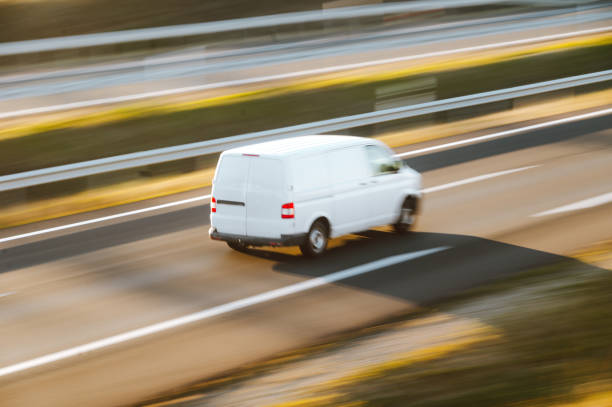 Van in motion on a highway A van in motion on a highway delivery van stock pictures, royalty-free photos & images